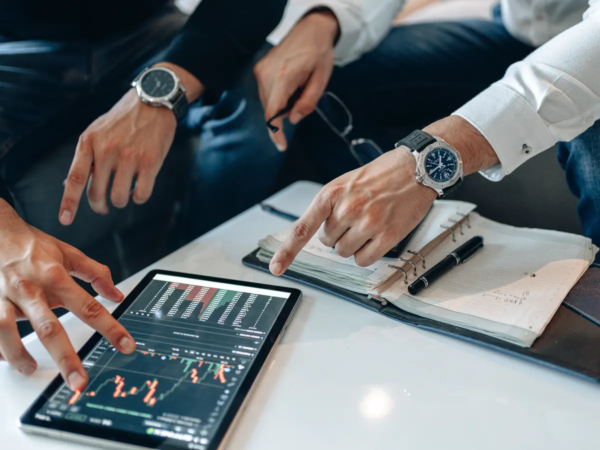 Investors reviewing figures on a tablet